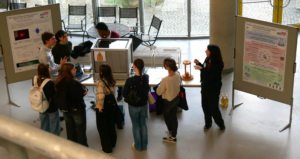 photo showing Thomas Koller, Bara'a Al-khateeb, Pranay Chittem and Karin Jess presenting experiments and a poster to students